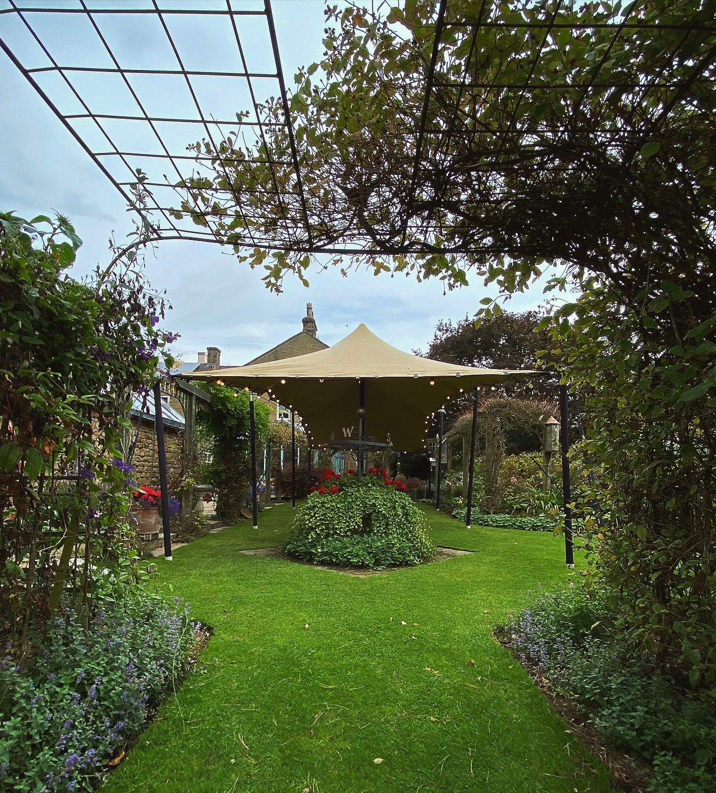 a stretch tent / party tent in a garden with festoon lighting