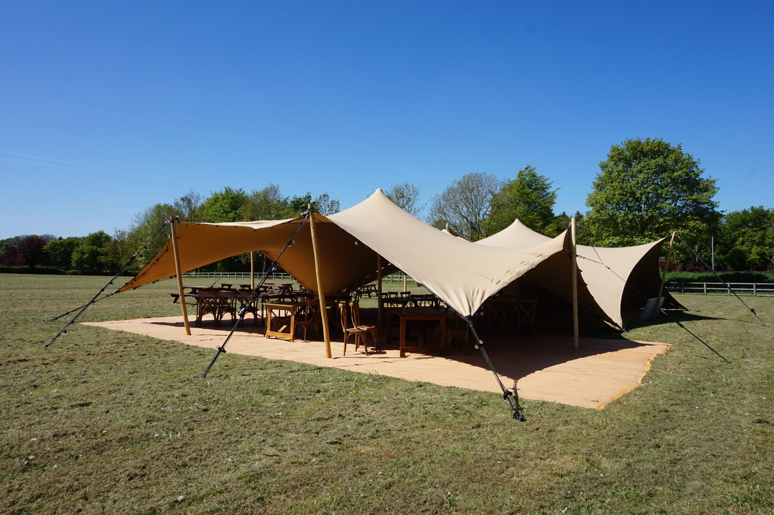 chin coloured stretch tents set up for a party on a sunny day
