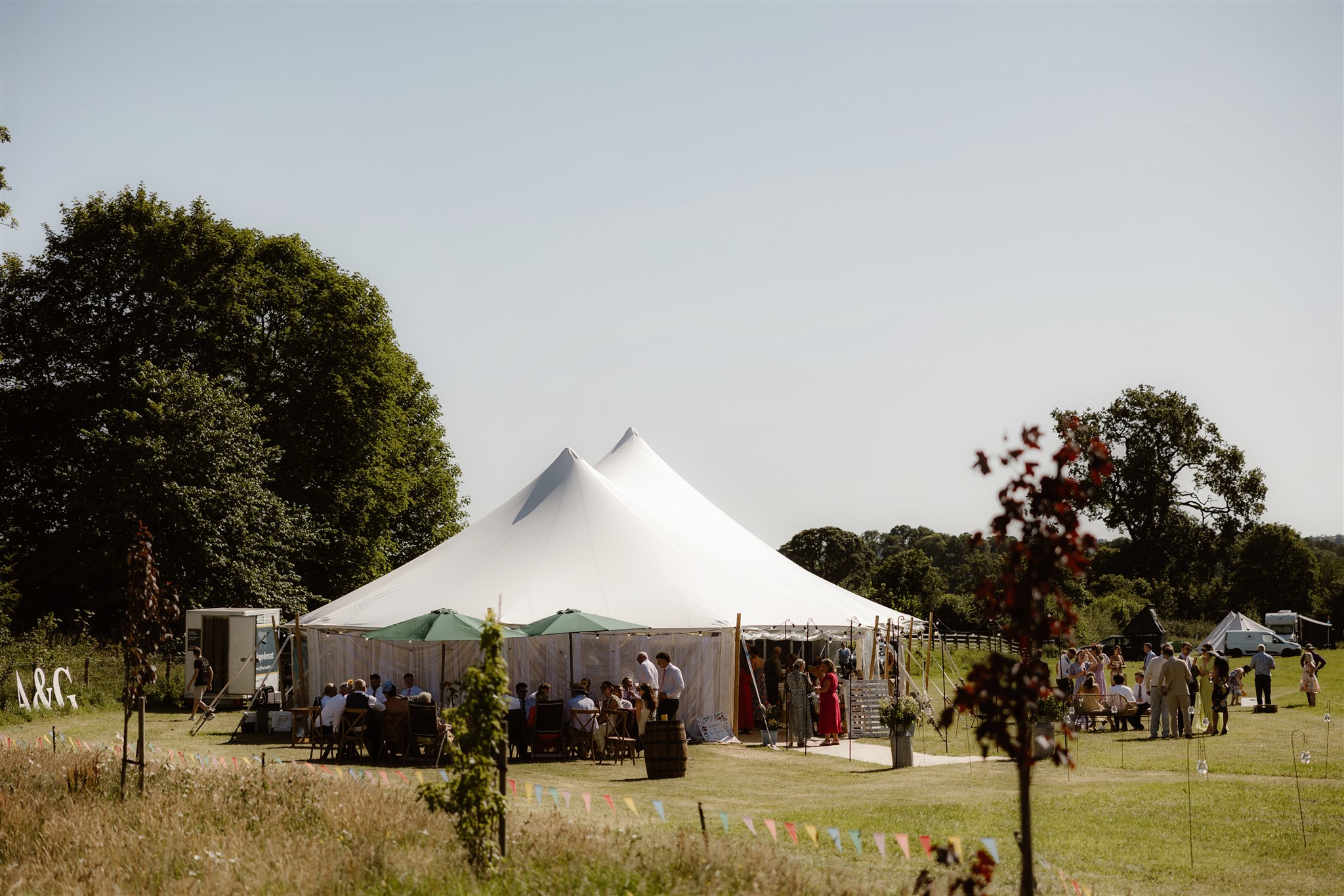 guests outside white marquee for a summer wedding, tent by Countryside Events, photo by Jono Symonds Photo and Film